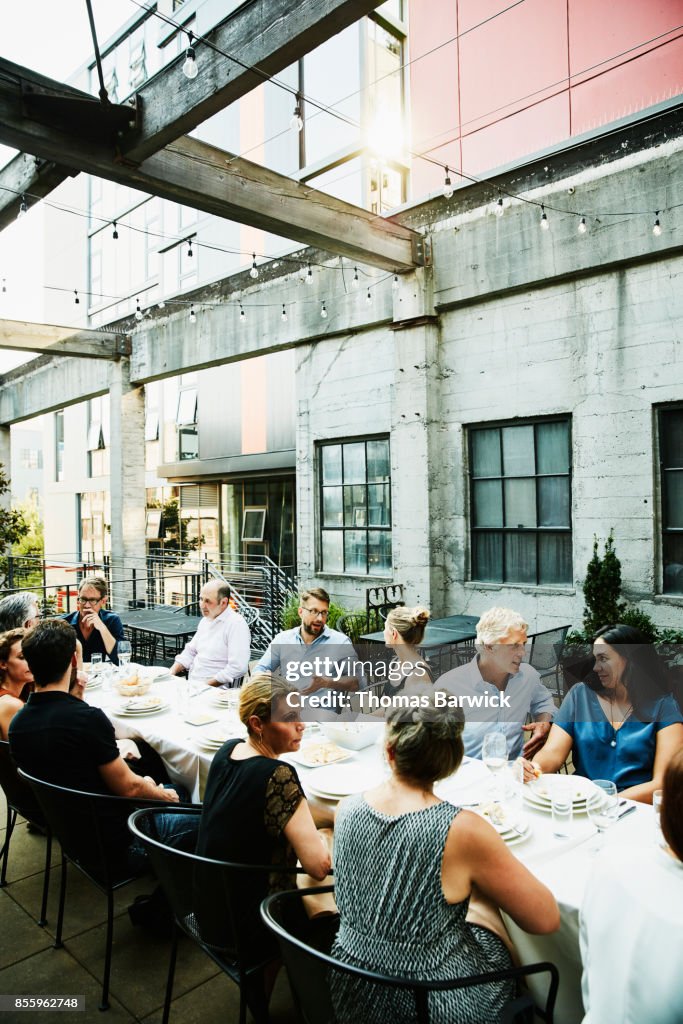 Group of friends enjoying celebration dinner on restaurant patio