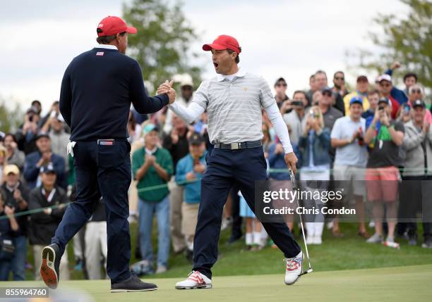 Kevin Kisner celebrates with teammate Phil Mickelson of the U.S. Team after winning 2 and 1 on the 17th hole during the Saturday morning foursomes...