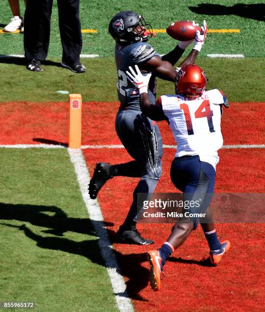 Wide receiver Stephen Louis of the North Carolina State Wolfpack makes a reception for a touchdown over defensive back Evan Foster of the Syracuse...