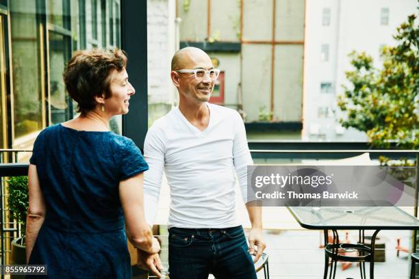 husband and wife saying goodbye to friends after dinner party on restaurant patio on summer evening - leaving restaurant stock pictures, royalty-free photos & images