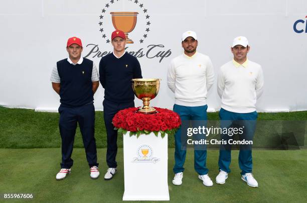 Patrick Reed and Jordan Spieth of the U.S. Team stand alongside Jason Day of Australia and Louis Oosthuizen of South Africa and the International...