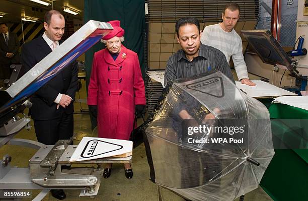 Queen Elizabeth II visits Fulton Umbrellas factory on the Isle of Dogs on March 25, 2009 in London, England. During the visit the Queen was shown...