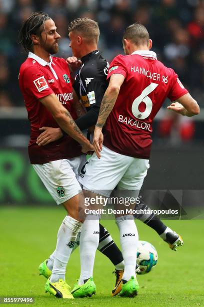 Mickael Cuisance of Borussia Monchengladbach battles for the ball with Martin Harnik and Marvin Bakalorz of Hannover 96 during the Bundesliga match...