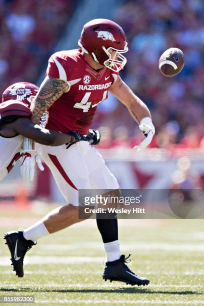 Austin Cantrell of the Arkansas Razorbacks fumbles the ball after being hit by Terrill Hanks of the New Mexico State Aggies at Donald W. Reynolds...