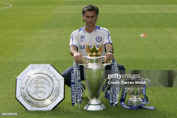 Chelsea manager Jose Mourinho poses with the Community Shield, Barclays Premiership and Coca Cola League Cup trophies