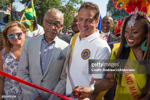 New York Governor Andrew Cuomo, standing next to Al Sharpton, prepares to cut a ribbon to mark the beginning of the annual West Indian Day parade on...