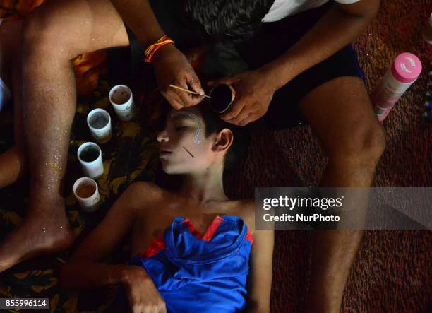 An Indian man applies make up on an artist before traditional Ramleela,a play narrating the life of Hindu God Ram,on ocassion of Dussehra festival,in...