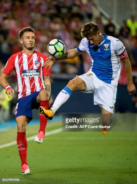Atletico Madrid's midfielder from Spain Saul Niguez vies with Leganes' midfielder from Argentina Alexander Szymanowski during the Spanish league...