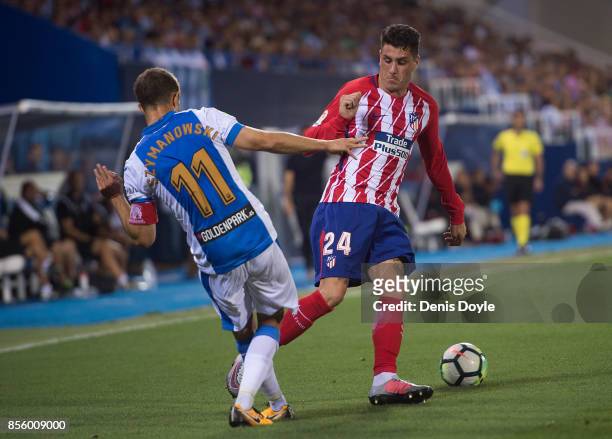 Jose Maria Gimenez of Club Atletico de Madrid is tackled by Alexander Szymanowski of CD Leganes during the La Liga match between Leganes and Atletico...