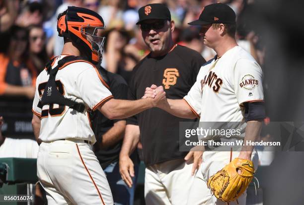 Matt Cain of the San Francisco Giants shakes the hand of catcher Buster Posey as manager Bruce Bochy looks on after the top of the fourth inning...