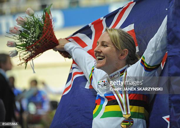 New Zealand's Alison Shanks celebrates her gold medal with her national flag after the podium ceremony of the women's Individual Pursuit during the...