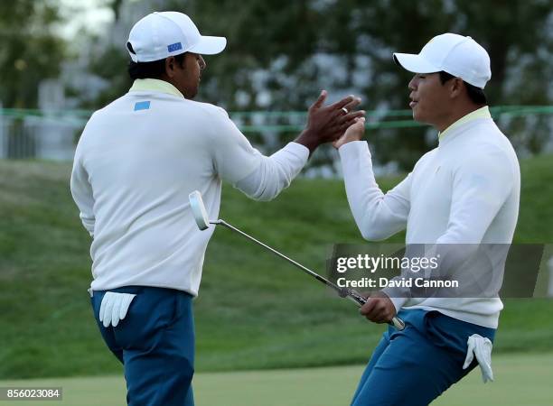 Anirban Lahiri of India and the International team is congratulated by his partner Si Woo Kim of South Korea after Lahiri had holed a crucial birdie...