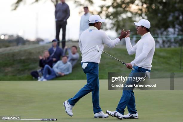 Anirban Lahiri of India and the International Team and Si Woo Kim of South Korea and the International Team celebrate on the 17th green during...