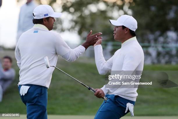 Anirban Lahiri of India and the International Team and Si Woo Kim of South Korea and the International Team celebrate on the 17th green during...