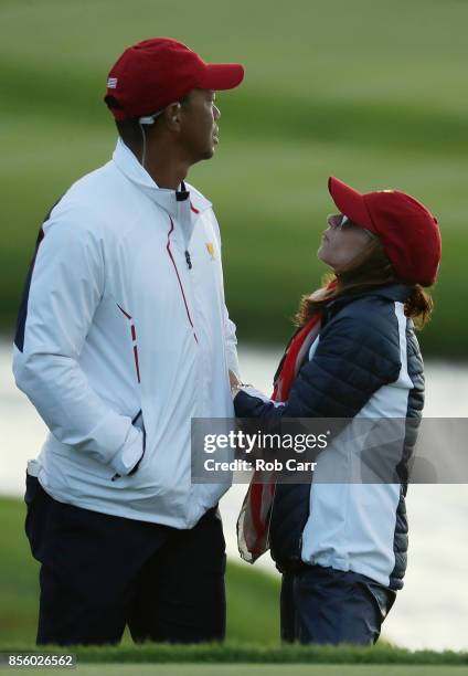 Captain's assistant Tiger Woods of the U.S. Team and Erica Herman look on during Saturday four-ball matches of the Presidents Cup at Liberty National...