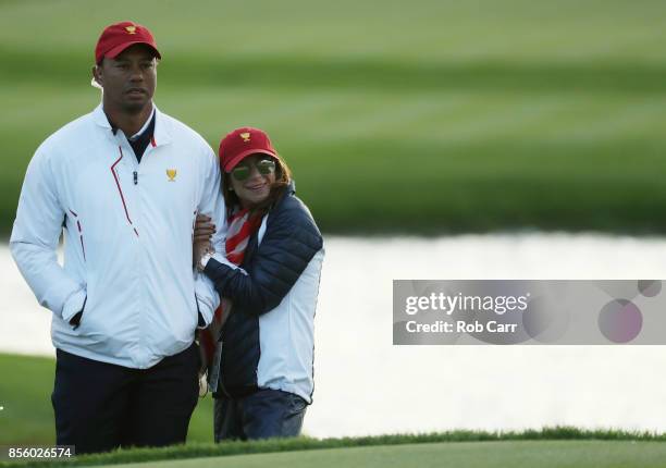 Captain's assistant Tiger Woods of the U.S. Team and Erica Herman look on during Saturday four-ball matches of the Presidents Cup at Liberty National...