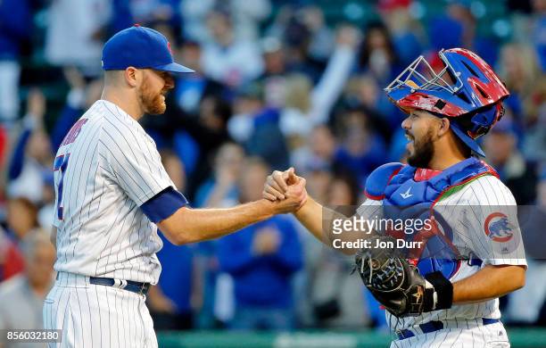 Wade Davis of the Chicago Cubs and Eugenio Suarez celebrate their win over the Cincinnati Reds at Wrigley Field on September 30, 2017 in Chicago,...