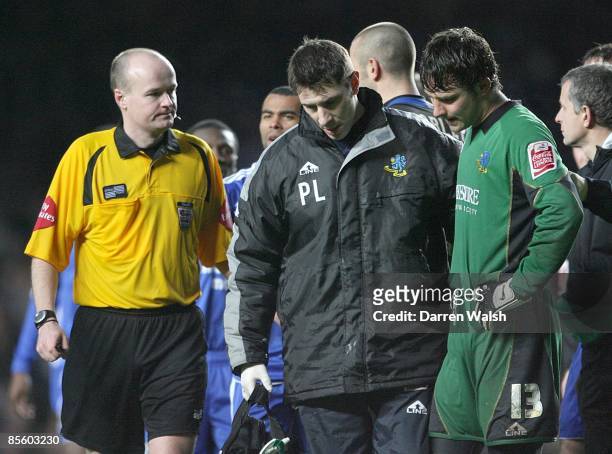Referee Lee Mason looks on as Macclesfield Town's Physio Paul Lake walks off the pitch with a dejected Tommy Lee after being sent off after a...