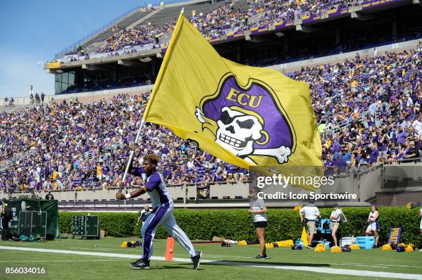 East Carolina Pirates cheerleader runs with a flag after a touchdown during a game between the South Florida Bulls and the East Carolina Pirates at...