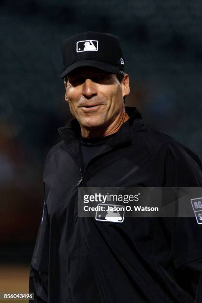 Umpire Angel Hernandez stands on the field during the first inning between the Oakland Athletics and the Seattle Mariners at the Oakland Coliseum on...