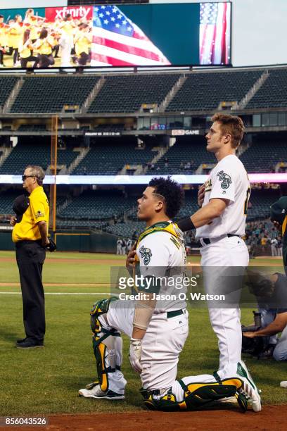 Bruce Maxwell of the Oakland Athletics kneels during the national anthem in front of Mark Canha before the game against the Seattle Mariners at the...