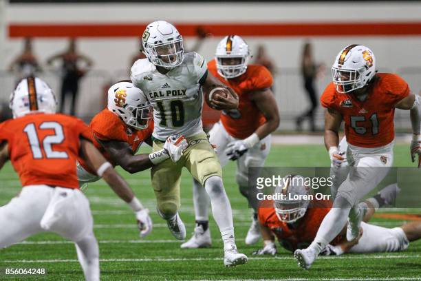 Quarterback Khaleel Jenkins of the Cal Poly Mustangs looks for a clear path through a host of Idaho State Bengal defenders during second half action...