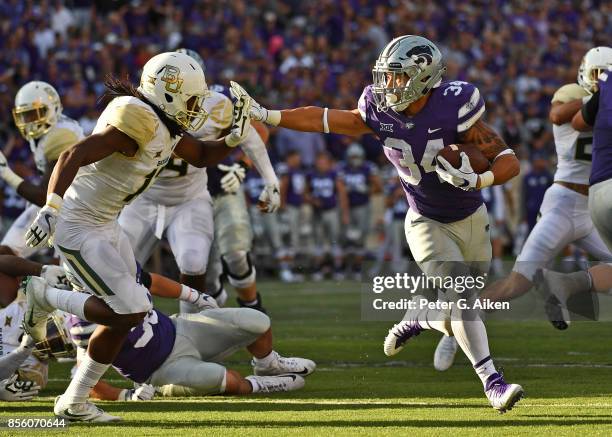 Running back Alex Barnes of the Kansas State Wildcats rushes up field against free safety Davion Hall of the Baylor Bears during the second half on...