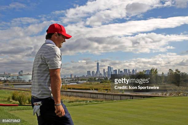 Golfer Patrick Reed walks to the 14th tee with the New York city skyline in the background during the third round of the Presidents Cup at Liberty...