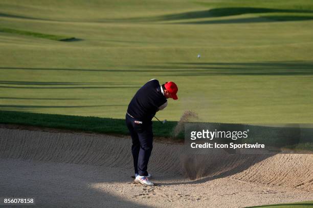 Golfers Patrick Reed hits out of a bunker on the 4th hole during the third round of the Presidents Cup at Liberty National Golf Club on September 30,...