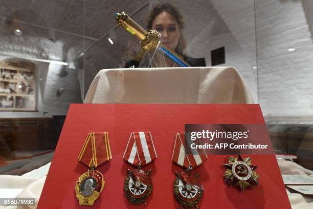 Picture taken on September 29, 2017 in Moscow shows a woman looking at personal belongings of British KGB agent Kim Philby during the exhibition "Kim...