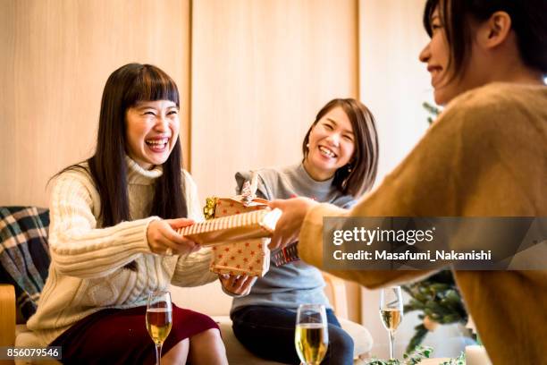 japanese girls enjoying gifts exchange - christmas gift exchange stock pictures, royalty-free photos & images