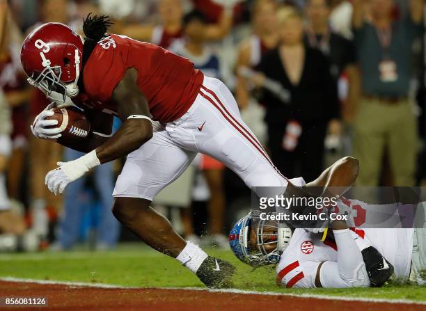 Bo Scarbrough of the Alabama Crimson Tide scores a touchdown against Detric Bing-Dukes of the Mississippi Rebels at Bryant-Denny Stadium on September...