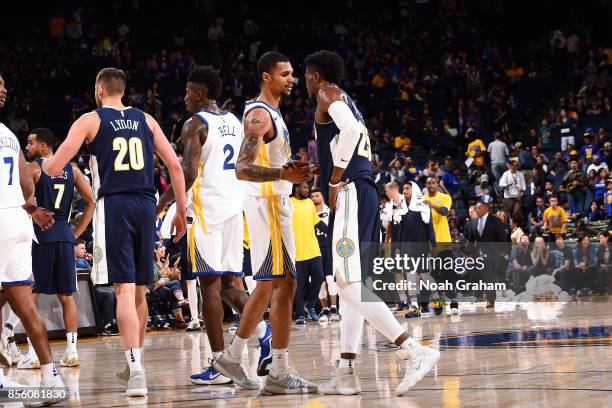 Michael Gbinije of the Golden State Warriors shakes hands with Malik Beasley of the Denver Nuggets after the game during a preseason game on...