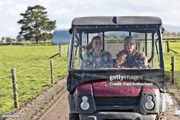 farm girls riding in a farm vehicle. - new zealand dairy farm stock pictures, royalty-free photos & images