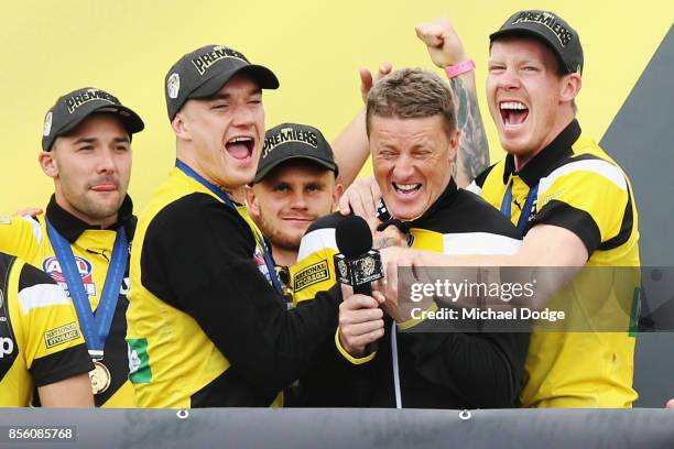 Dustin Martin of the Tigers and Jack Riewoldt hug Tigers head coach Damien Hardwick as players celebrate winning yesterday's AFL Grand Final, at Punt...