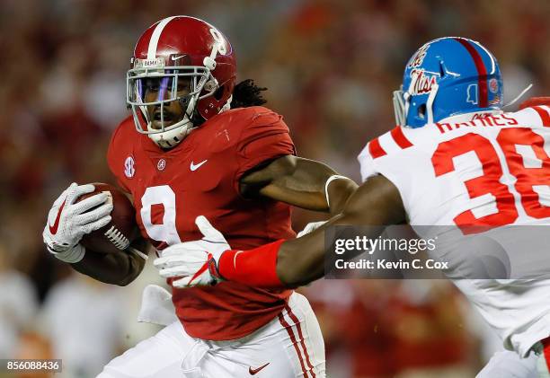 Bo Scarbrough of the Alabama Crimson Tide rushes away from Marquis Haynes of the Mississippi Rebels at Bryant-Denny Stadium on September 30, 2017 in...