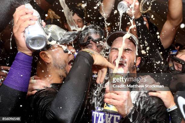 Carlos Gonzalez and Nolan Arenado of the Colorado Rockies are doused by his teammates in the lockerroom at Coors Field on September 30, 2017 in...