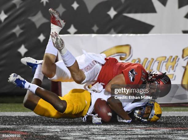 Wide receiver Tre Hartley of the San Jose State Spartans misses a pass in the end zone as he is hit by defensive back Dalton Baker of the UNLV Rebels...