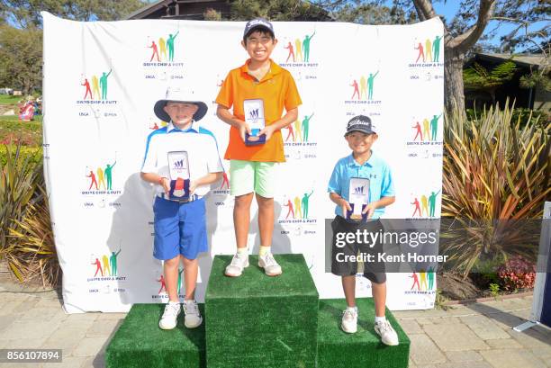 Second, first and third place putting skills for boys age 10-11 category Adam Anderson, left, Kai Hirayama, center, and Tyler Tamayori pose with...