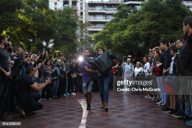 Two people bring in ballot boxes as crowds gather outside Escola Industrial of Barcelona school in protest and defence of the polling station from...