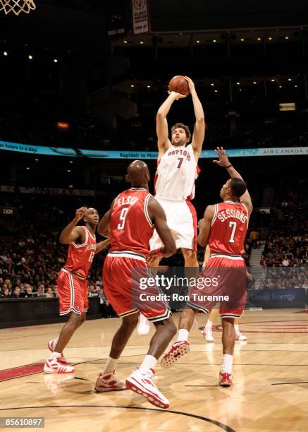 Andrea Bargnani of the Toronto Raptors takes a shot over Ramon Sessions and Francisco Elson of the Milwaukee Bucks during a game on March 25, 2009 at...