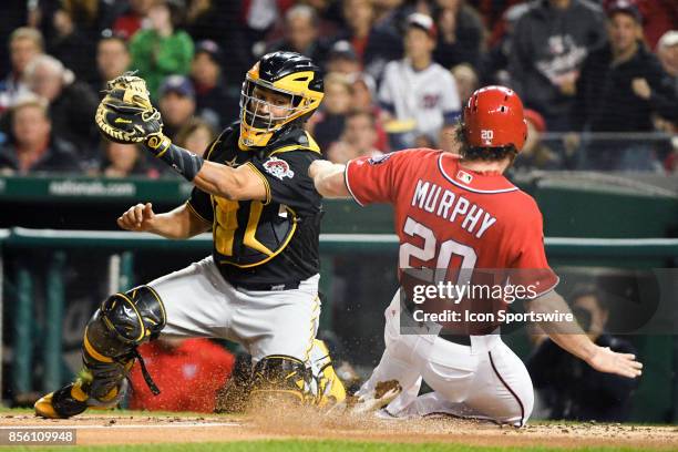 Washington Nationals second baseman Daniel Murphy scores in the second inning as Pittsburgh Pirates catcher Elias Diaz takes the throw during an MLB...