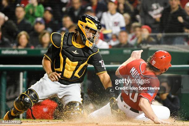 Washington Nationals second baseman Daniel Murphy scores in the second inning as Pittsburgh Pirates catcher Elias Diaz takes the throw during an MLB...