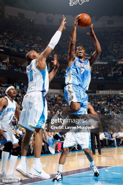 Chauncey Billups of the Denver Nuggets shoots over James Posey and David West of the New Orleans Hornets on March 25, 2009 at the New Orleans Arena...