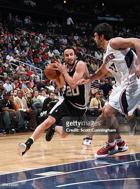 Manu Ginobili of the San Antonio Spurs drives to the basket against Zaza Pachulia of the Atlanta Hawks at Philips Arena on March 25, 2009 in Atlanta,...