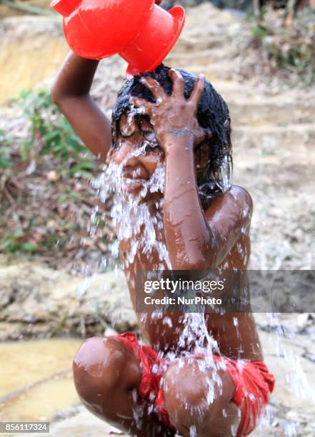 Coxs Bazar, Bangladesh. September 23, 2017. A Rohingya refugee girl takes bath at a refugee camp in Coxs Bazar, Bangladesh on September 23, 2017....
