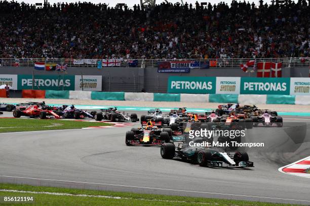 Lewis Hamilton of Great Britain driving the Mercedes AMG Petronas F1 Team Mercedes F1 WO8 leads the field into turn two at the start during the...