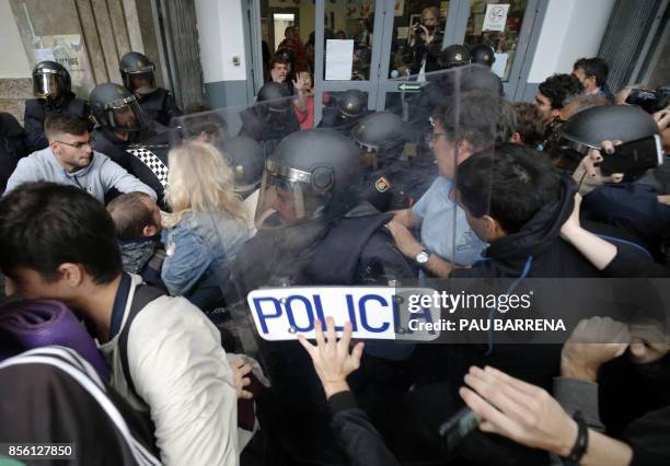 Spanish police officers clash with people outside a polling station in Barcelona, on October 1 on the day of a referendum on independence for...