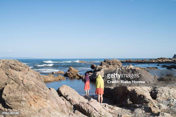 women standing on the rock - rieko honma stock-fotos und bilder