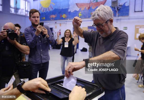 Man raises his fist as he casts his ballot in a polling station in Barcelona, on October 1 on the day of a referendum on independence for Catalonia...